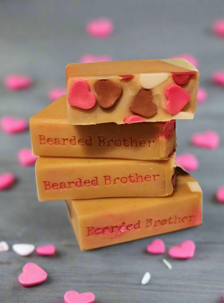 Three bars of soap with heart-shaped sprinkles stacked on a neutral background, branded 'Bearded Brother'.
